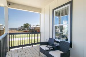 a balcony with chairs and a view of the ocean at Luxury Family home near Casinos with King Bed, steps away from the Beach, Game Room, and Free Parking in Gulfport