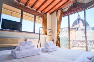 a room with towels on a bed with a large window at The Art Luxury Home in Florence