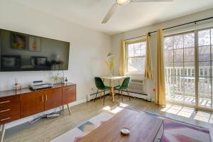 a living room with a table and chairs and windows at Asbury Park Condo Less Than Half-Mi to Beach and Boardwalk! in Asbury Park