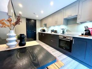 a kitchen with blue cabinets and a vase on a table at Fabulous Large apartment in great location in Bath