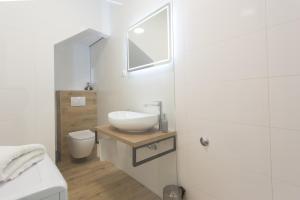 Baño blanco con lavabo y aseo en Apartman Stobreč en Split