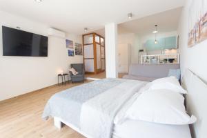 1 dormitorio blanco con 1 cama grande y TV en Apartman Stobreč en Split