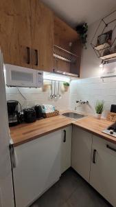 a kitchen with white cabinets and a wooden counter top at TUDOR Apartment in Kaprun