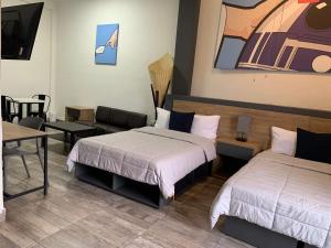 Habitación de hotel con 2 camas y mesa en Hostal 170 en Orizaba