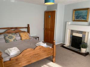a bedroom with a wooden bed and a fireplace at Fryers Cottage, Seamer, 3 Bed cottage sleeps 5 people in Seamer