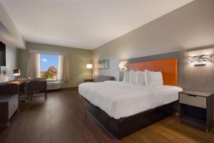 um quarto de hotel com uma cama grande e uma secretária em Best Western Sugar Sands Inn & Suites em Destin