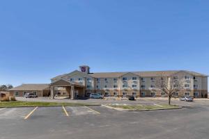 a large building with a parking lot in front of it at Sleep Inn & Suites Pleasant Hill - Des Moines in Pleasant Hill