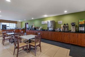 a restaurant with a counter and tables and chairs at Sleep Inn & Suites Pleasant Hill - Des Moines in Pleasant Hill