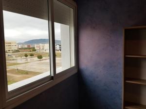 een kamer met een raam met uitzicht op de stad bij Appartement lala yasmine in Fès