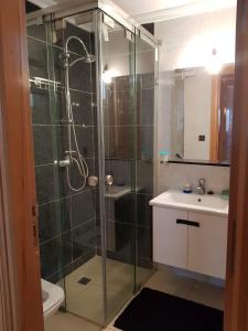 W łazience znajduje się szklana kabina prysznicowa i umywalka. w obiekcie Appartement lala yasmine w Fezie