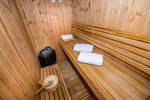 uma sauna de madeira com duas toalhas e uma lata de lixo em Out of Africa Resort em Had Nes