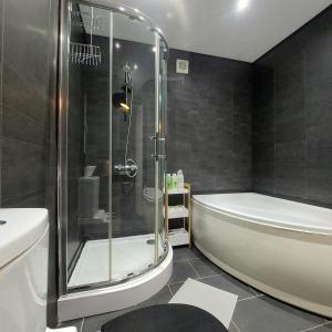 a bathroom with a shower and a tub and a sink at Woodstock Townhouse Belfast in Belfast