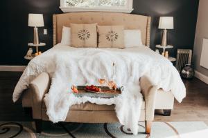 a bed with a white blanket and a tray of fruit at Taylor Creek Lodge in Gold Beach