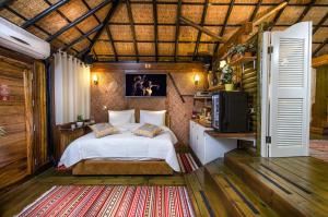 a bedroom with a bed and a tv in it at Out of Africa Resort in Had Nes +152 photos