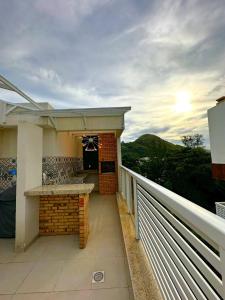 Un balcón de una casa con barra y una cocina en Coberturas ou apartamentos 1min da praia do recreio com Vista Mar, en Río de Janeiro