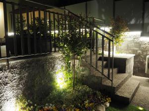 un jardín con una escalera con luces. en La Finestra sui Faraglioni, en Aci Castello
