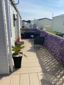 einen Balkon mit lila Blumen auf einem Haus in der Unterkunft Spacious Holiday Home - Romney Sands in Littlestone-on-Sea