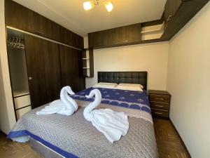 a bedroom with swans towels on a bed at Apart La Posada in Tacna