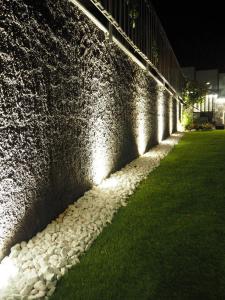 uma parede de pedra com uma linha de luzes em La Finestra sui Faraglioni em Aci Castello