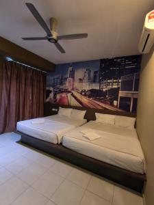 1 dormitorio con 2 camas y ventilador de techo en GOLDEN GUEST HOUSE KUANTAN en Kuantan