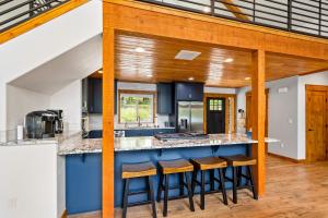 an open kitchen with blue countertops and wooden beams at Willow Bay in Priest River