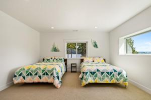 two beds in a white room with a window at Willow Bay in Priest River