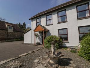 a house with a bird bath in front of it at Moors Farm in Cinderford