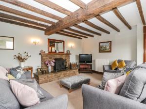a living room with couches and a fireplace at Moors Farm in Cinderford