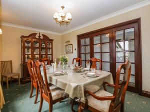 a dining room with a table and chairs and a chandelier at Moors Farm in Cinderford