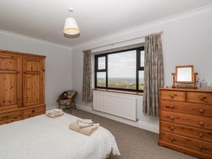 a bedroom with a bed and a dresser and a window at Moors Farm in Cinderford