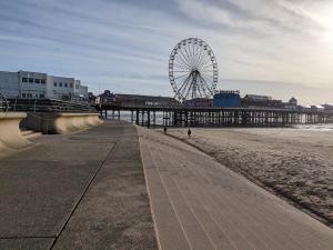 a ferris wheel on the beach next to a pier at Willin House Hotel in Blackpool