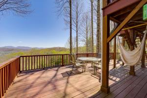 a wooden deck with a hammock and a table and chair at Game Room and Mtn Views Banner Elk Cabin in Banner Elk