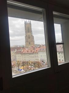 a window with a view of a building with a church at Cathédrale Saint-Nicolas Bnb in Fribourg