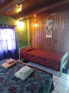 two beds in a room with wooden walls at Laura in Rosario