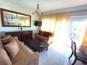 salon z kanapą i stołem w obiekcie H_paradise w mieście Iraklitsa +1 zdjęcie