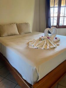 a bed with two swans towels on it at Aqua Lounge Bar & Hostal in Bocas del Toro