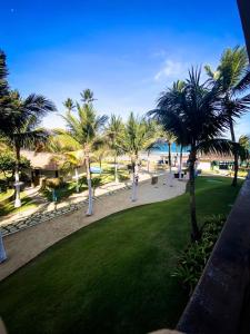 Blick auf einen Park mit Palmen und das Meer in der Unterkunft Muro Alto -Flat - Porto de Galinhas Beira mar in Porto De Galinhas