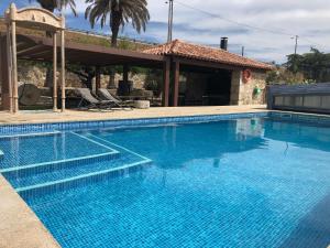 uma grande piscina azul com uma casa em Quinta das Pias - Holiday Farm em Pinhel