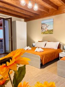 sypialnia z łóżkiem z pomarańczową pościelą i kwiatem w obiekcie La Vie Fuille Bed and Breakfast w mieście Riposto
