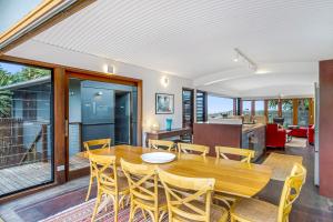 a dining room with a wooden table and chairs at Fuller Holidays - Belongil Beachfront Pavilion, 18 Childe St in Byron Bay