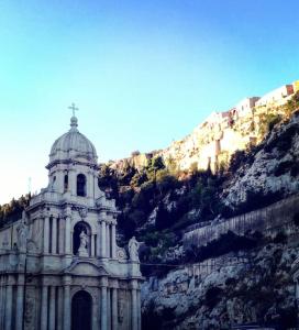 a building on the side of a mountain at Il Cappero Scicli - casetta con vista in centro storico in Scicli +5 photos
