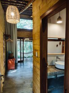 a bathroom with a stone wall and a door at Vila Floresta - Chalé Pato Mergulhão in Alto Paraíso de Goiás