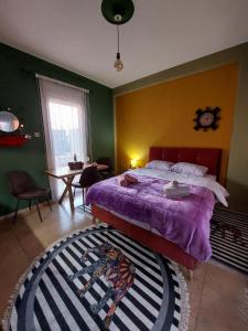 um quarto com uma cama com um edredão roxo em Φιλοξενία1 em Drama