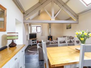 a kitchen and living room with a table and a couch at Beudy Bach Barn in Llanuwchllyn