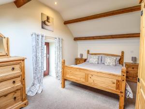 1 dormitorio con cama de madera y vestidor en Beudy Bach Barn en Llanuwchllyn