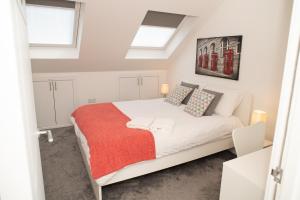 基德靈頓的住宿－Walnut Flats-F3, 1-Bedroom with Stunning Garden View, AC, Parking, Netflix, WIFI - Close to Oxford, Bicester & Blenheim Palace，卧室配有一张带红色毯子的白色床