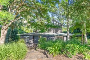 a house with palm trees in front of it at Fuller Holidays - Leah's Retreat - Relax in nature in Bangalow