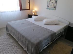 a bed with two pillows on it in a bedroom at Apartments with parking space Dajla, Novigrad - 6935 in Novigrad Istria