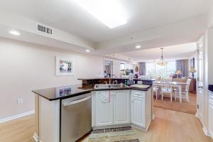 a kitchen with white cabinets and a dining room at Yacht Club Villas 3-505 in Myrtle Beach