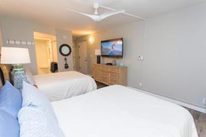 ワイレアにあるMaui Banyan Q-109のベッド2台と薄型テレビ付きのベッドルーム